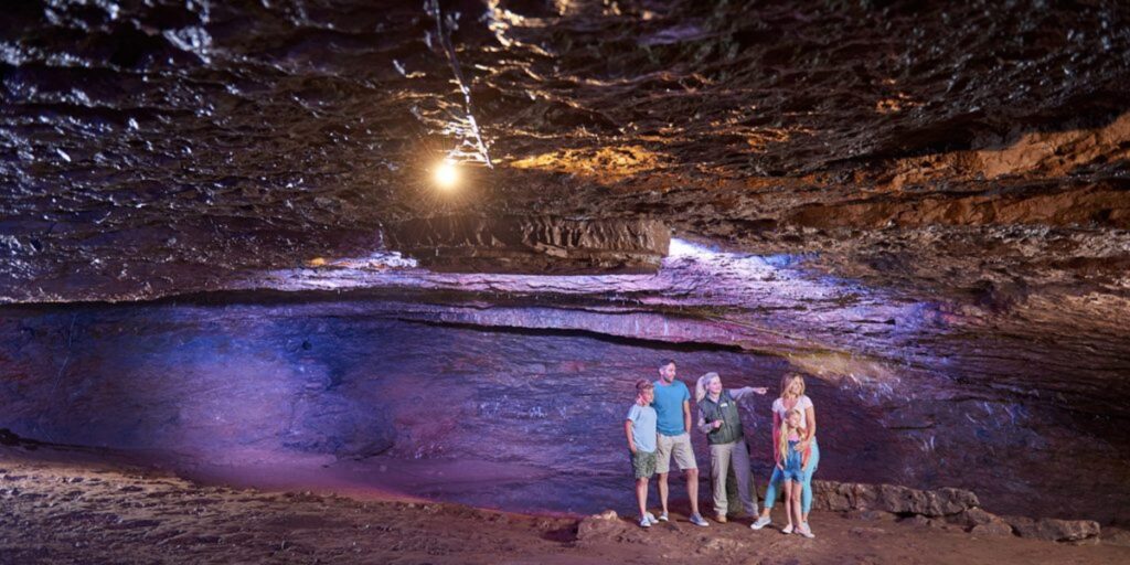 A family stands in the Witch's Parlour, an underground cavern at Wookey Hole.