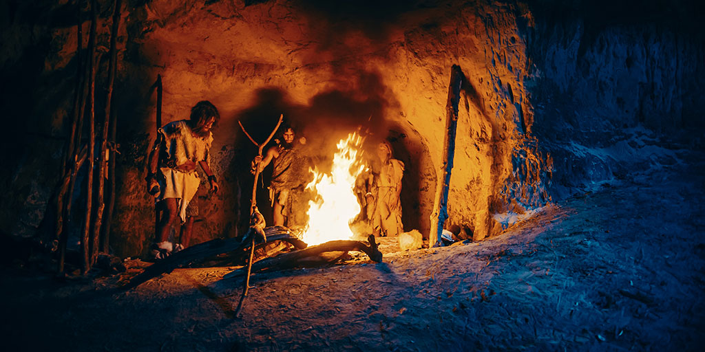 A model of a neanderthal family gathering round a fire in a cave.